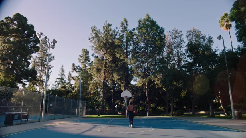 A man playing basketball outdoors
