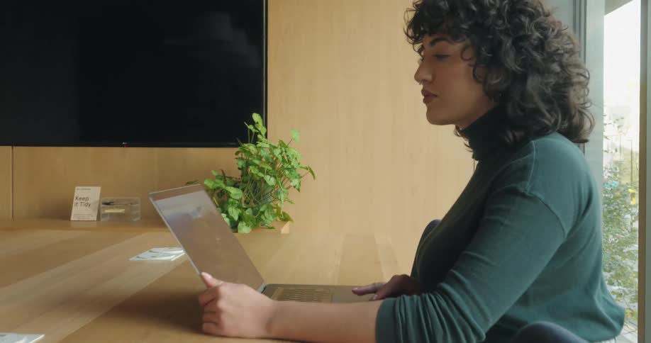 Woman sitting at an office table working on a laptop computer