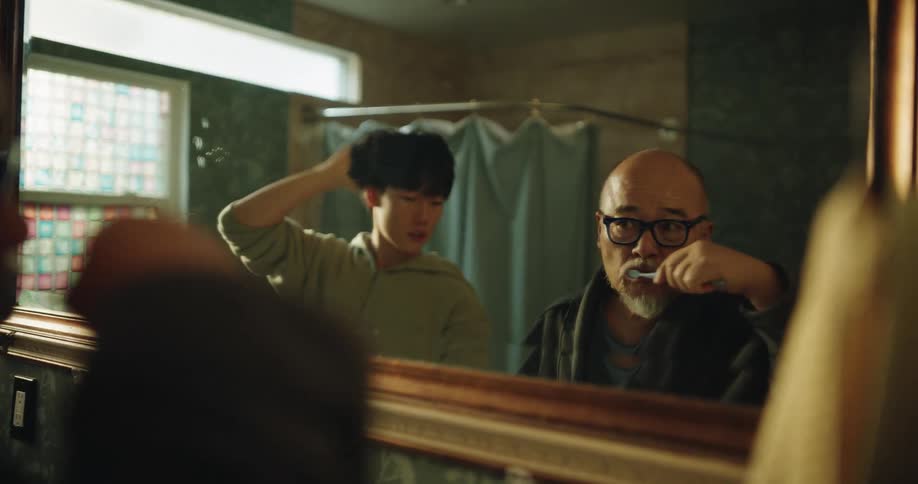 Asian father with teenage son preparing together in the bathroom during daytime