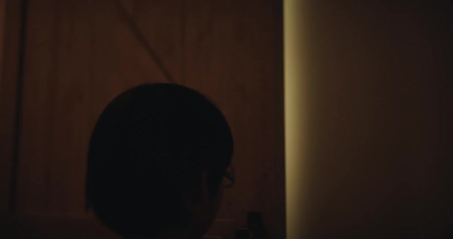 Two brothers pass each other at an indoor entrance to leave and enter a room
