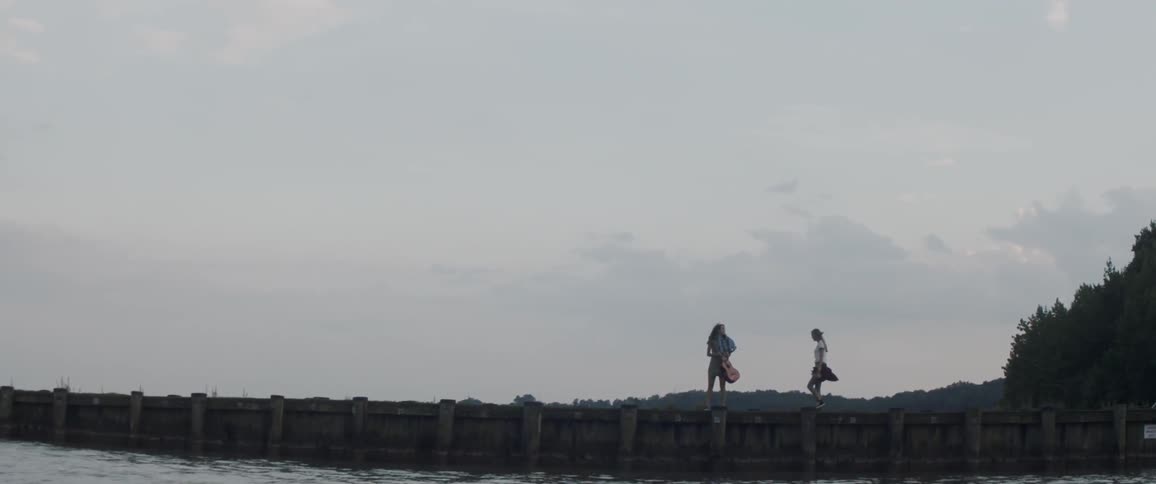 Two women walk out over the pier