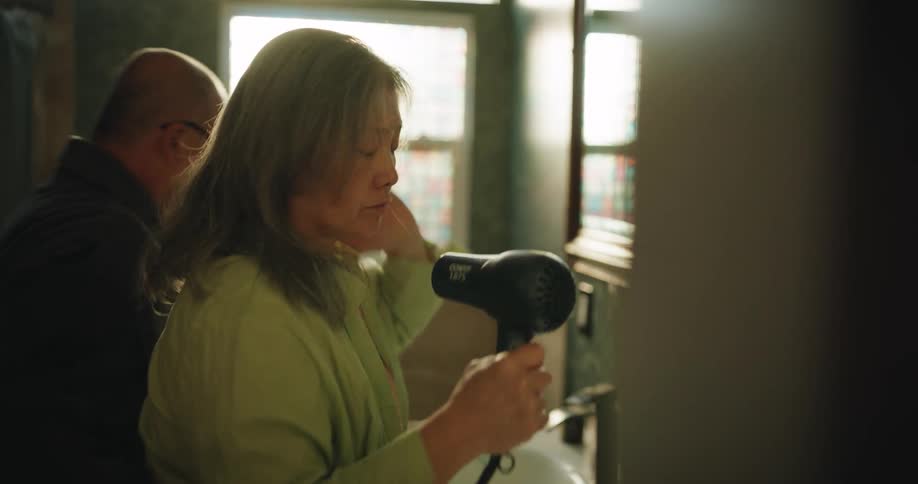 Close up of an asian woman drying her hair in the bathroom during daytime