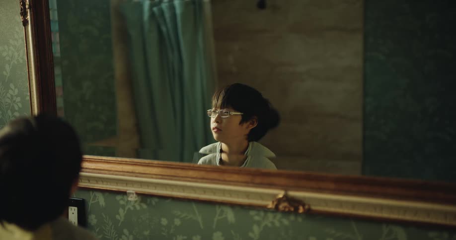 The boy smiles into the mirror