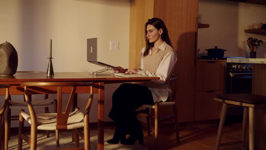 A woman sitting down at a laptop