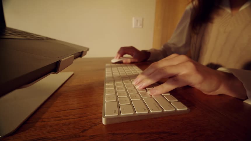 Woman sets a computer keyboard on the table and puts her hand on the mouse