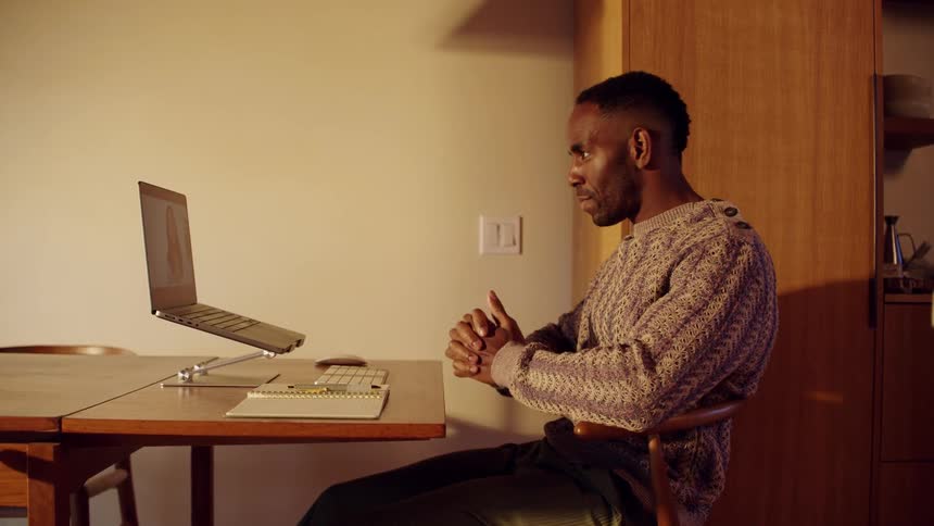 A man talking to a person on a computer