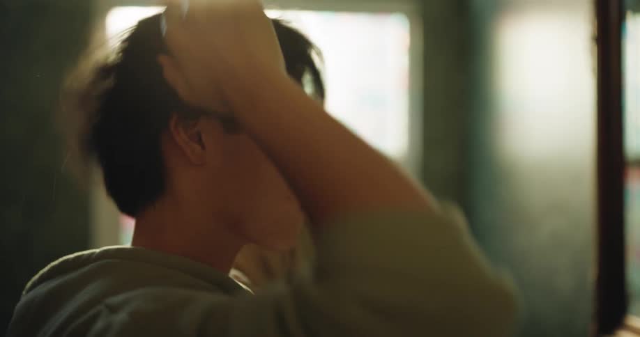 The man runs the sink water and cleans his hair