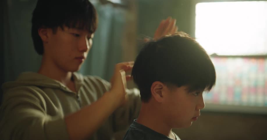 Person arranges a childs hair indoors with natural light