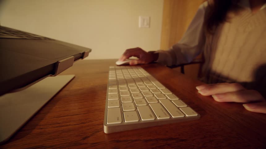 Woman sets a computer keyboard on the table and puts her hand on the mouse