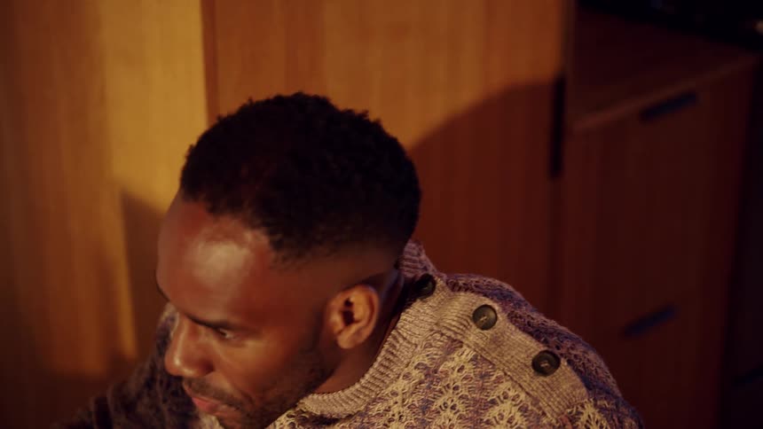 The man is talking and smiling in the room