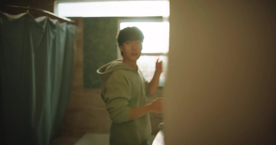 Asian father knocks and enters the bathroom to prepare with his teenage son in daytime