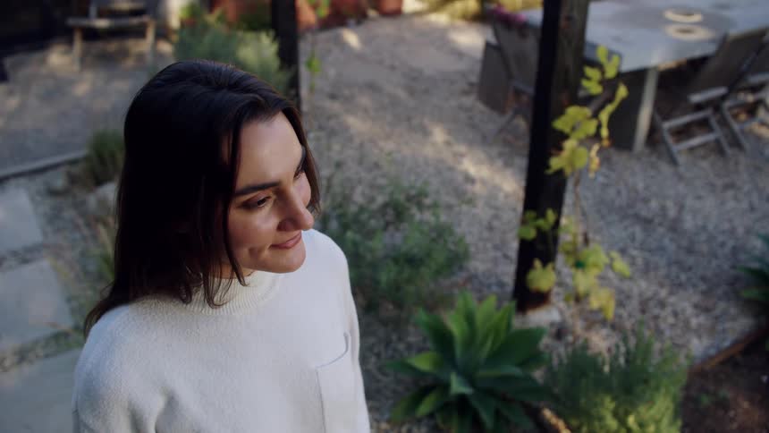 The woman smiles in her yard