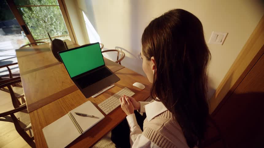 The woman opens her laptop and begins talking