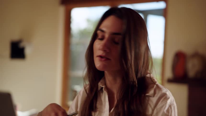 Woman talking indoors with natural light and a window in the background