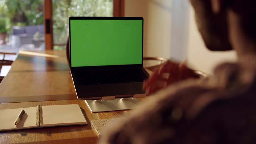 Man in a meeting facing a laptop on a table