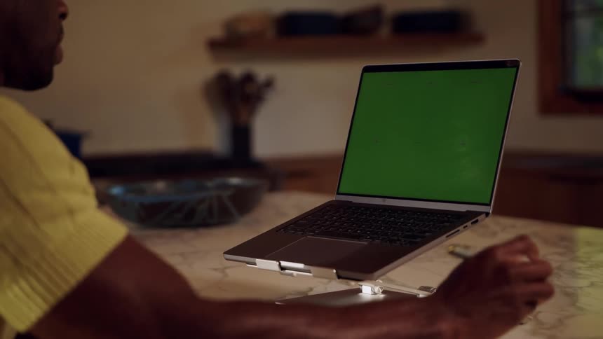 Man participates in a meeting using a laptop placed on a table
