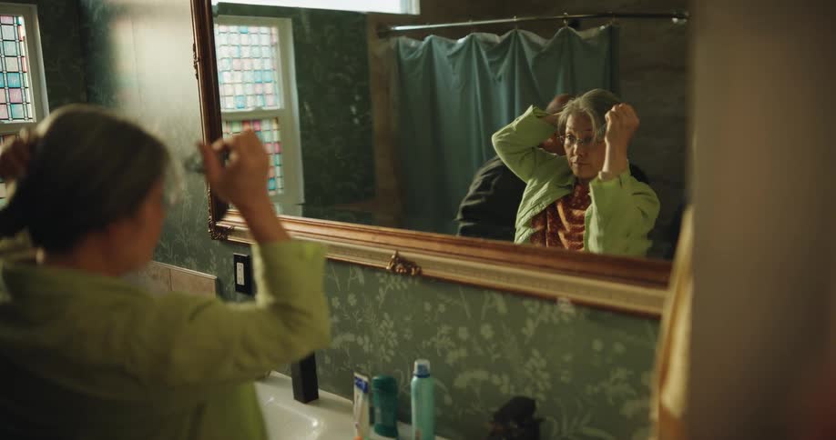 Family gets ready in front of a mirror in a bathroom with indoor lighting