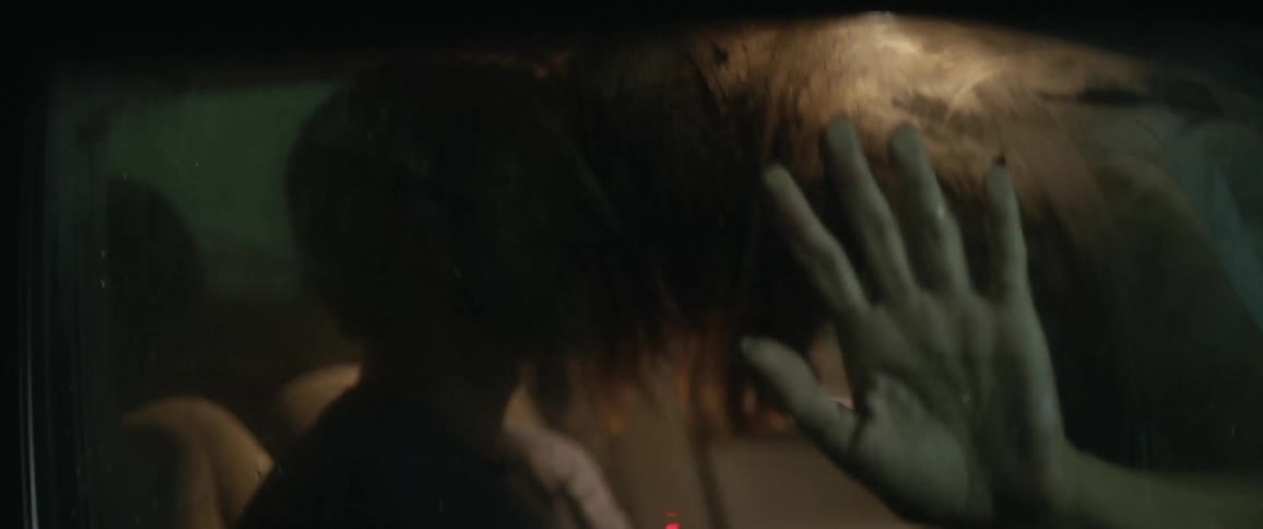 Man and woman are kissing inside a car at night