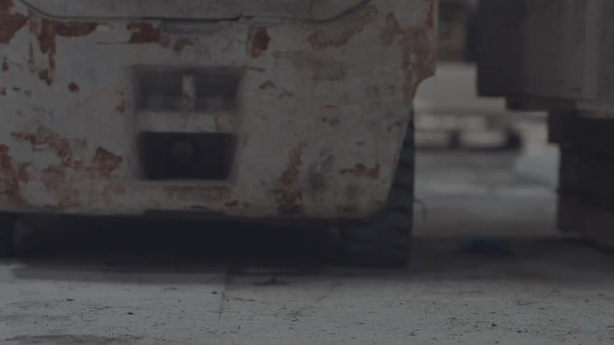 The forklift is being driven in the warehouse