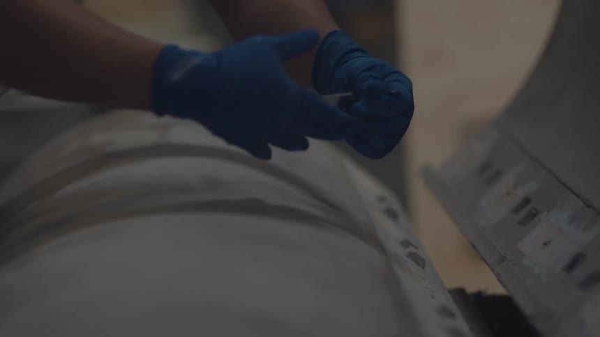The worker uses a chisel on the machine