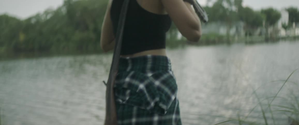 A woman is carrying a guitar by the lake
