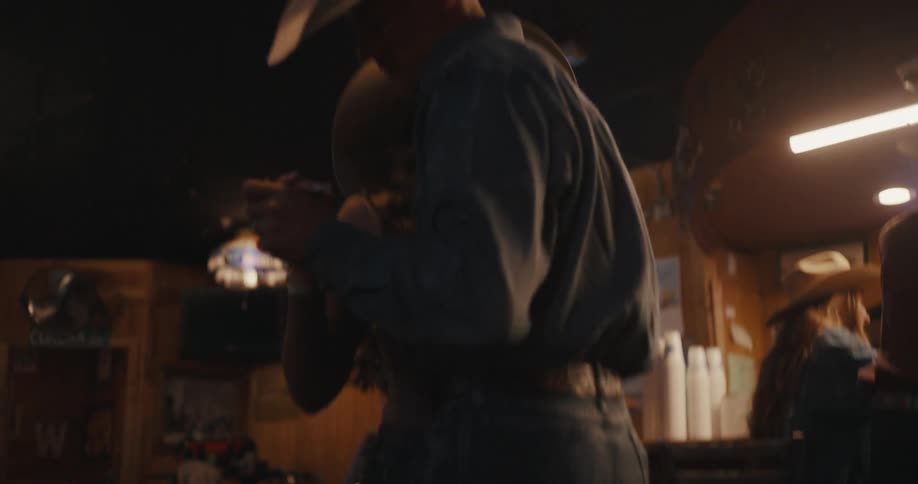 Man wearing a cowboy hat dancing with a partner indoors