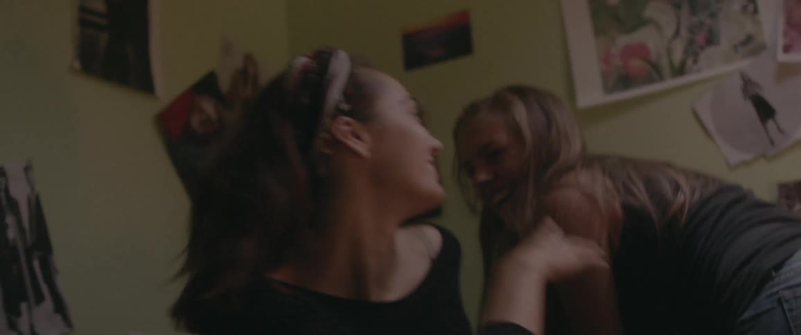 Two girls are laughing on a bed