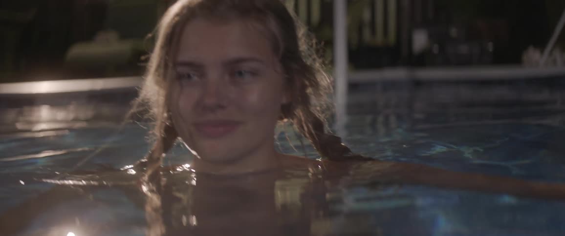 A woman is floating in the pool smiling