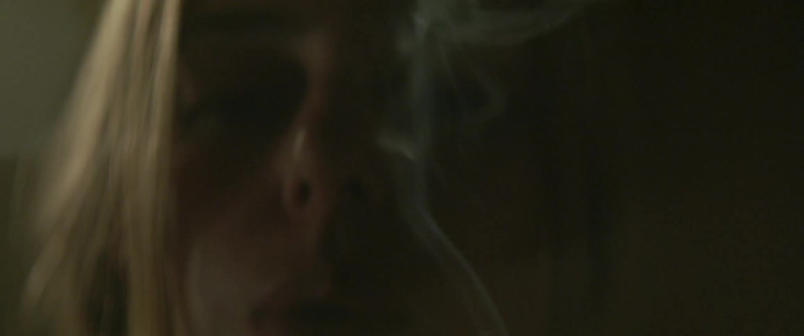 A woman lights a cigarette and smokes