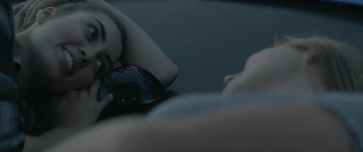 Two women lay outside at night