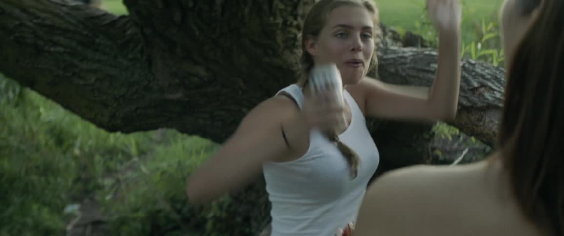 A woman catches a thrown grape in her mouth