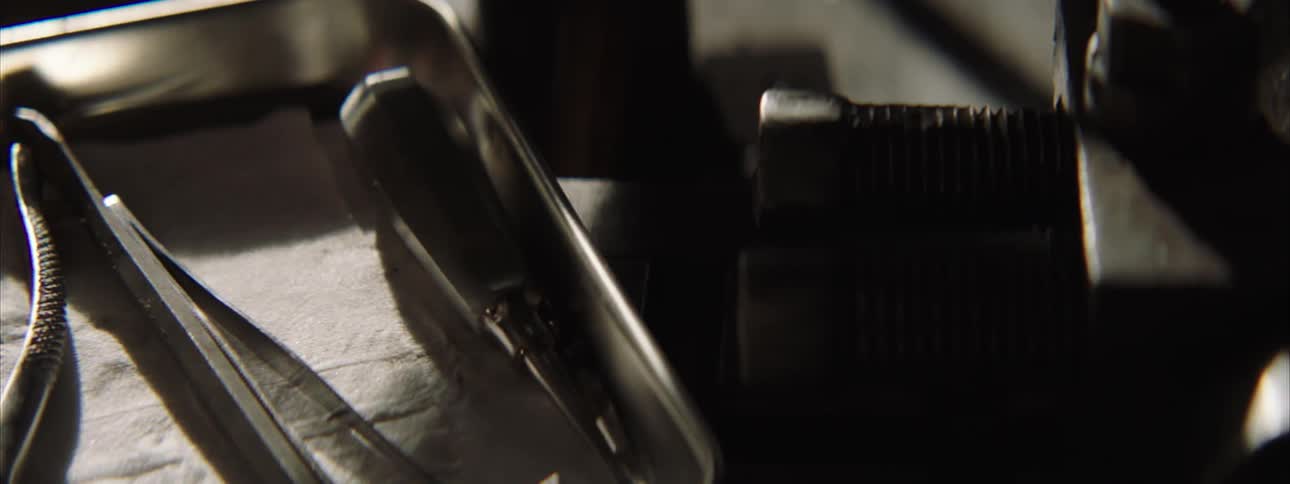 A shiny metal tray is placed down and a few small tools dropped atop it
