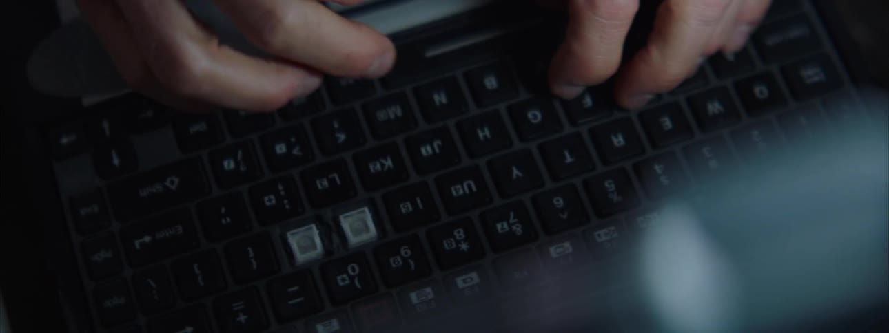Hands type on a laptop keyboard in closeup with focus on the keys