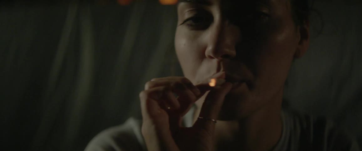 A woman lights and smokes a cigarette