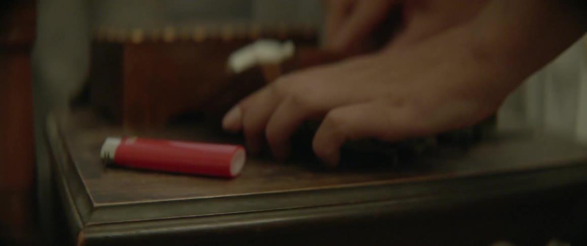A person grabs a lighter from the counter