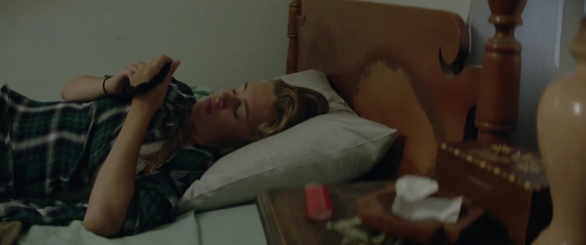 Woman laying in bed holding and twisting a hair tie