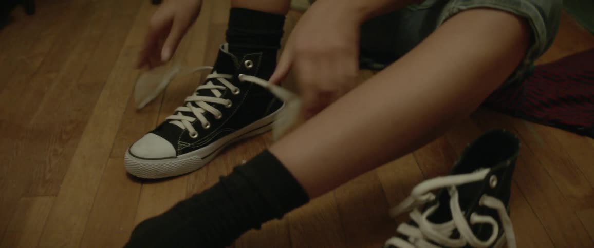 A girl puts on shoes and ties the laces