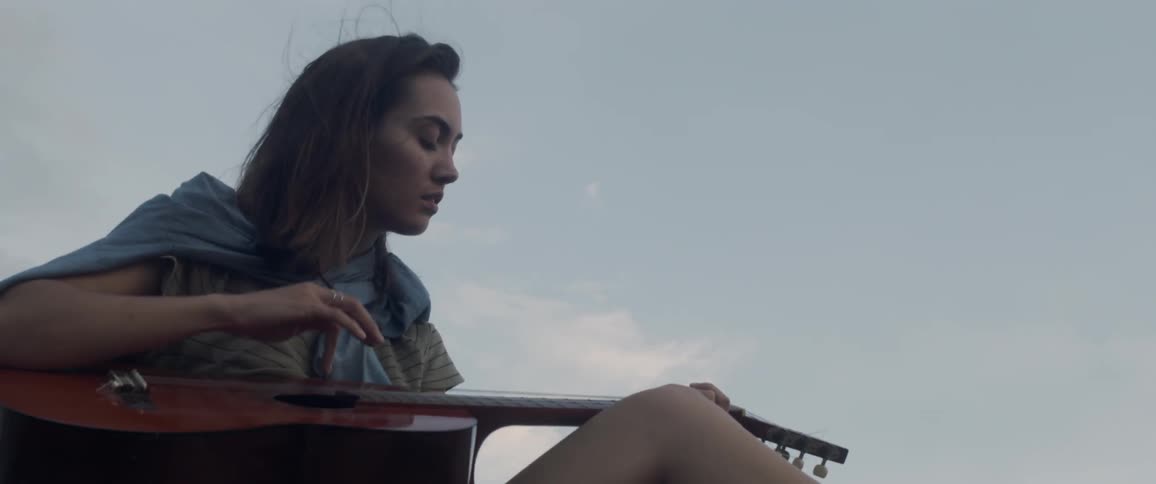 Woman plays a guitar outside