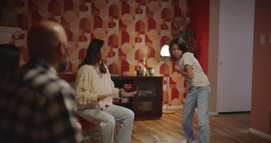 A joyful family plays charades together in a warm cozy living room