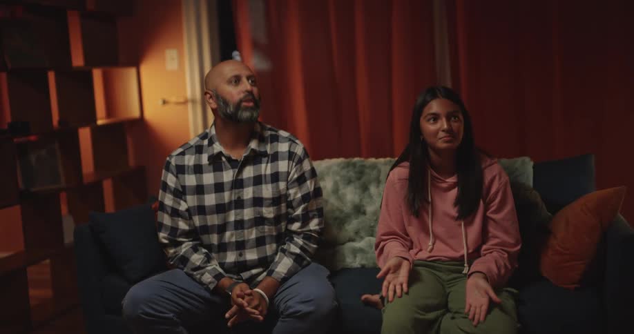 A family joyfully plays together on a cozy night in a dimly lit living room