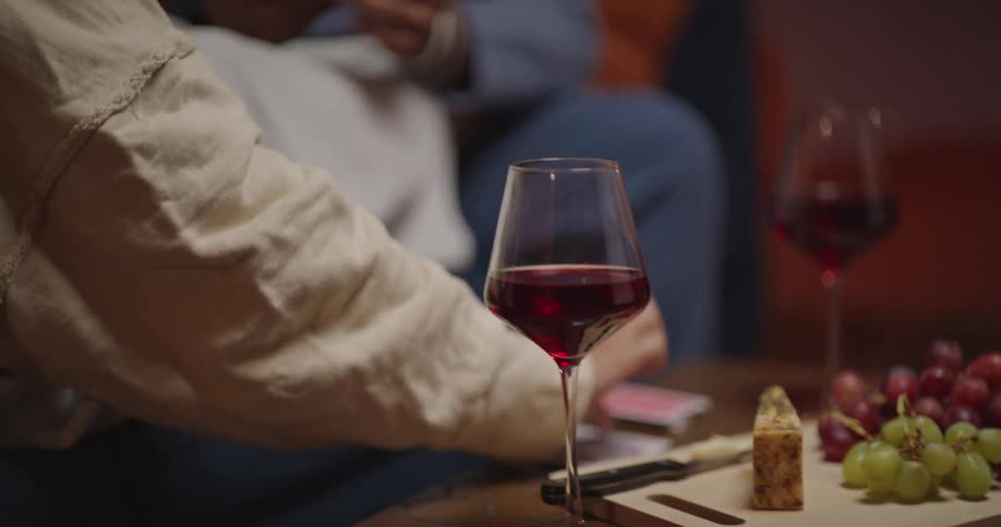 Close up of a couple eating and drinking together while playing card games in a living room