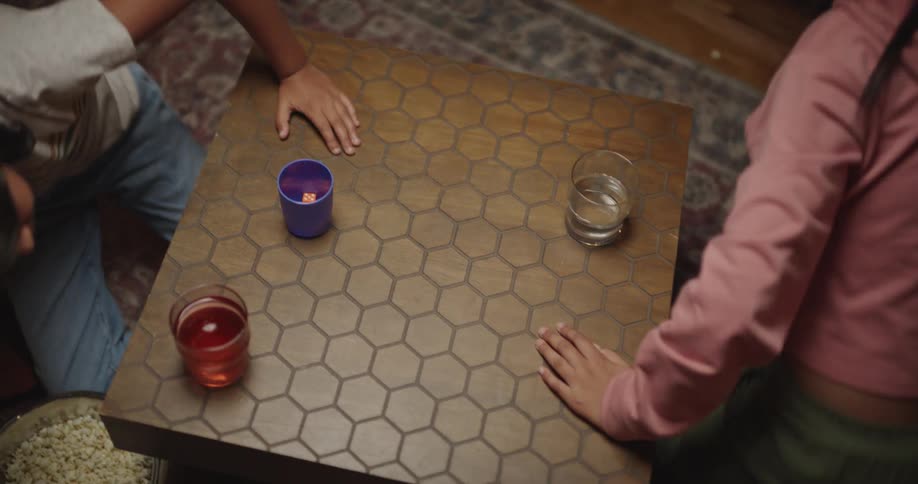 Family standing up next to a small table with a game board