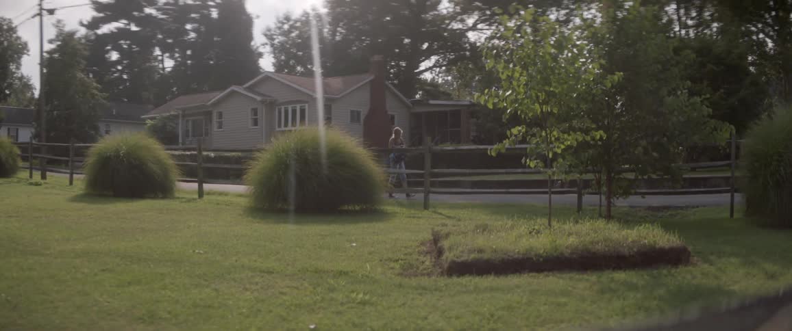 A woman walks past the fence ahead
