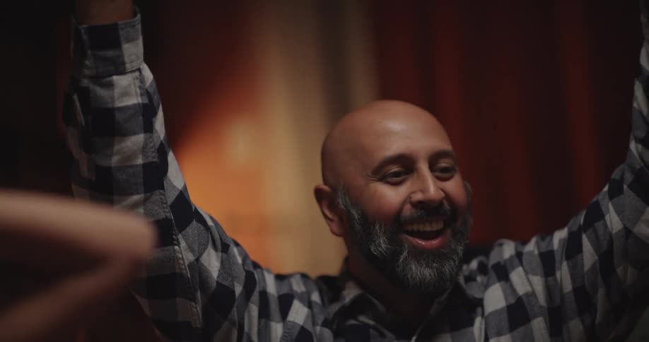 Man plays dice on a board and celebrates happily while surrounded by other people