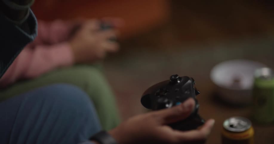 Two people playing a video game together at a table indoors