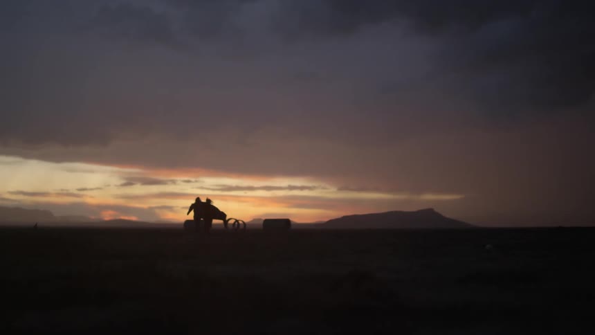 Two people walk on the field at dawn