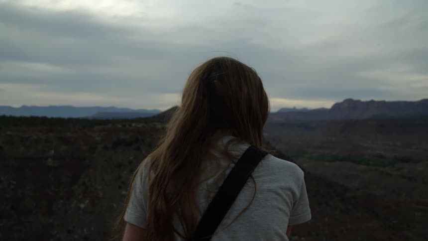 Woman sitting out in mountain wilderness on cloudy evening