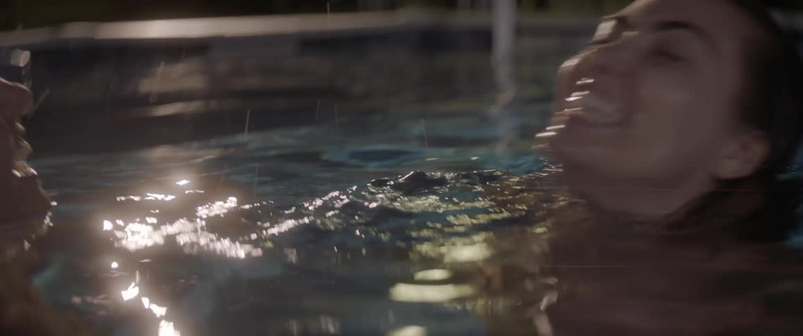 Two women splash in a swimming pool