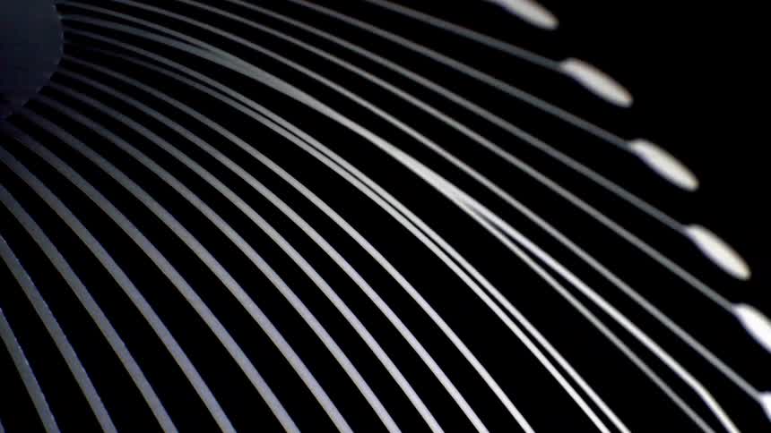 Closeup of curved metallic lines forming a sleek abstract pattern against a black background