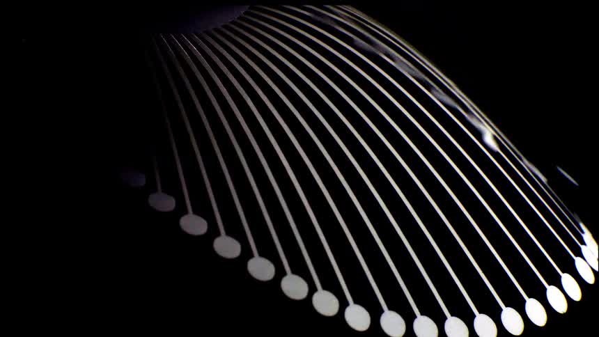 Abstract curved metallic lines with small circular elements on a dark background